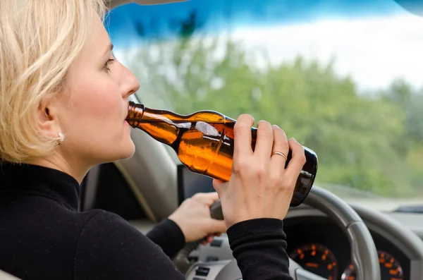 Woman alcoholic drinking as she drives the car — Stock Photo, Image