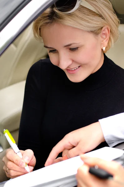 Kobieta podpisania kontrakt na zakup samochodu — Zdjęcie stockowe