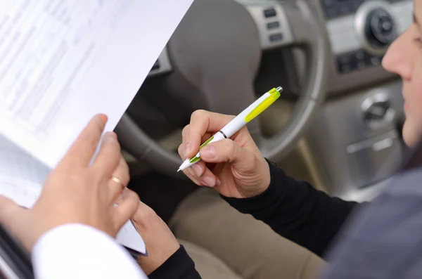 Woman driver signing paperwork