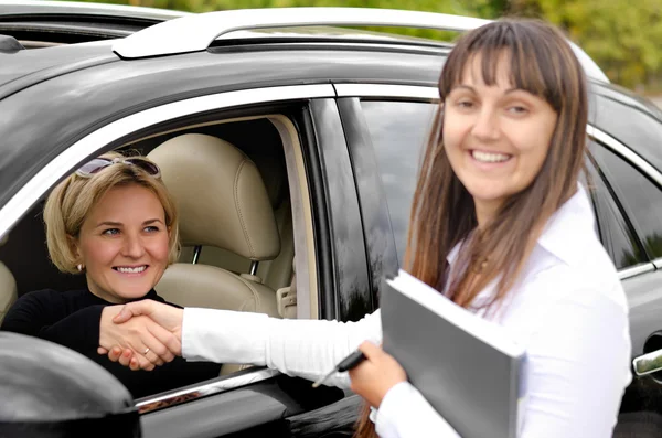 Vendedora apertando as mãos com um cliente — Fotografia de Stock