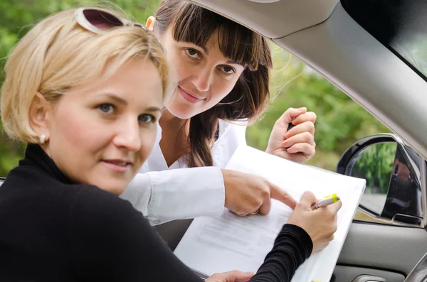 Vendedora ayudando a un cliente a comprar un coche — Foto de Stock