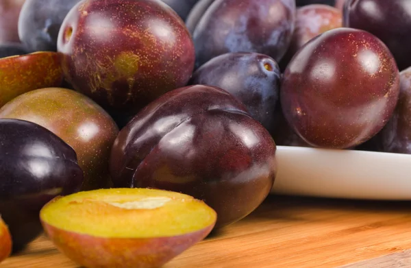 Fresh plums on wooden table — Stock Photo, Image