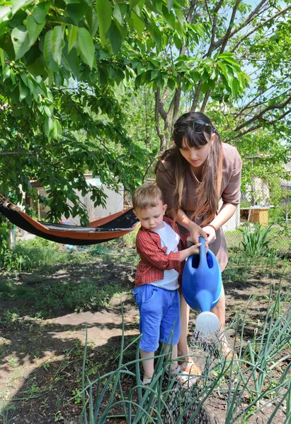 小男孩和他的母亲在花园里浇水 — 图库照片