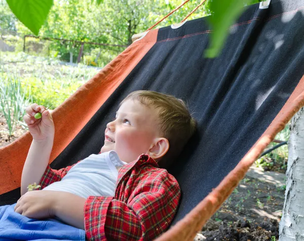 Feliz niño pequeño relajándose en una hamaca —  Fotos de Stock