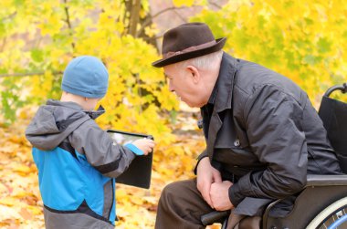 Çocuk izlerken dedesi ile bir tablet PC'yi kullanma