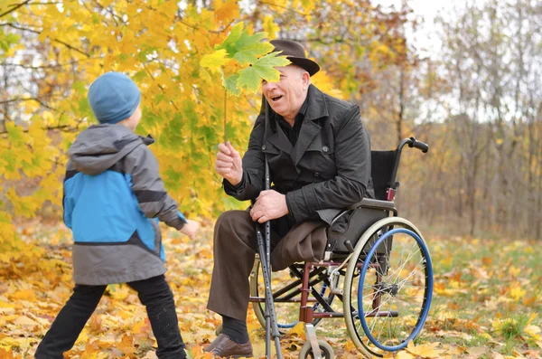 Jongen speelt met zijn handicap grootvader — Stockfoto