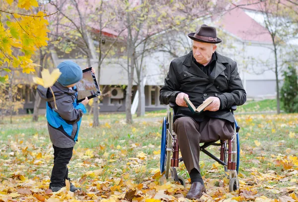 Disabled grandfather watching his grandson — Stock Photo, Image