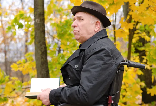 Zamyślony człowiek czytanie na park jesienią — Zdjęcie stockowe