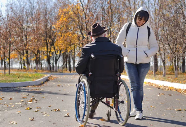 Kvinnan som talar till en handikappad man i rullstol — Stockfoto