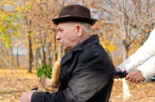 Frau nimmt älteren behinderten Mann beim Einkaufen — Stockfoto