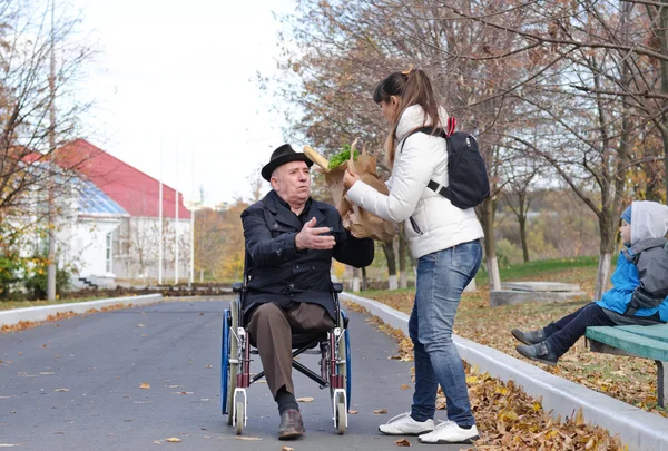 Mother helping her elderly disabled father — Stock Photo, Image