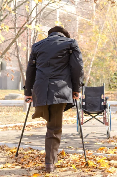 Handikappad enbenta man gå på kryckor — Stockfoto