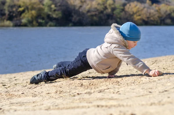 Jeune garçon jouant sur la plage de sable sur la côte — Photo