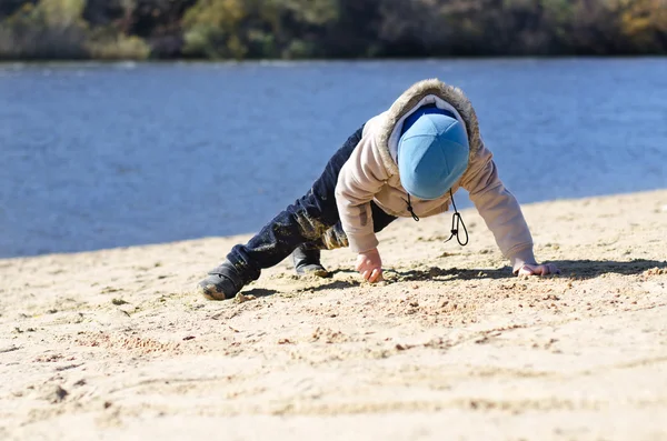 Młody chłopak gra na piaszczystej plaży na wybrzeżu — Zdjęcie stockowe