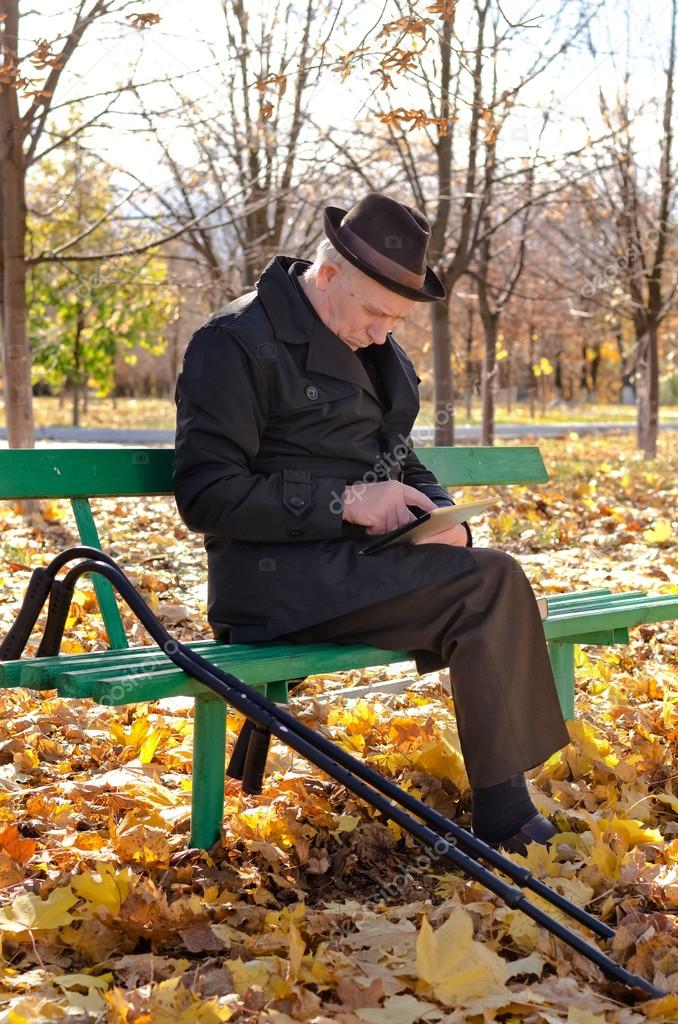 Handicapped elderly man sitting in the park
