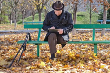 ihtiyar bir adamın koltuk değneği parkta tablet kullanma