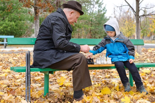 Disabled senior man teaching his grandson to play chess — Stock Photo, Image