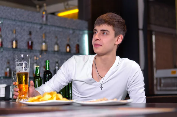 Young man sitting in the pub with a beer — Stock Photo, Image