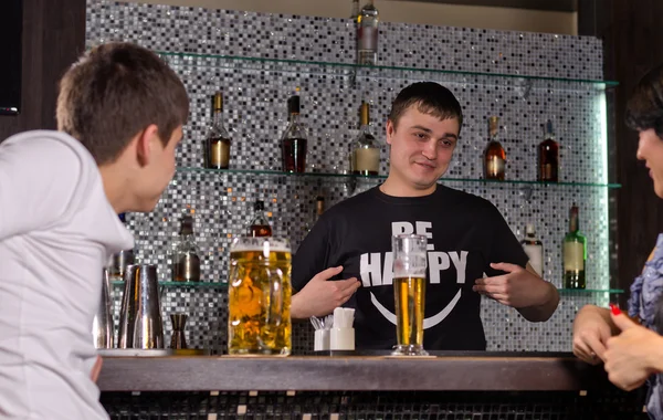 Barman atendiendo clientes en el mostrador del bar — Foto de Stock