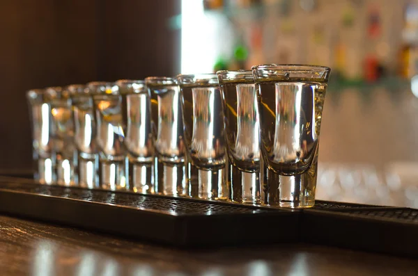 Fila de vasos en un mostrador de bar — Foto de Stock