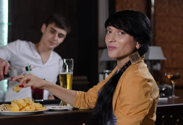 Junge Frau genießt einen Imbiss an der Bar — Stockfoto
