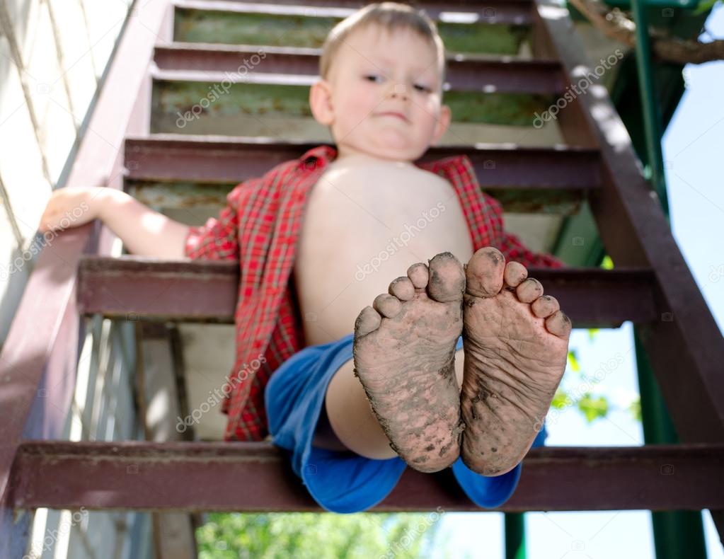 Little boy showing off his dirty feet