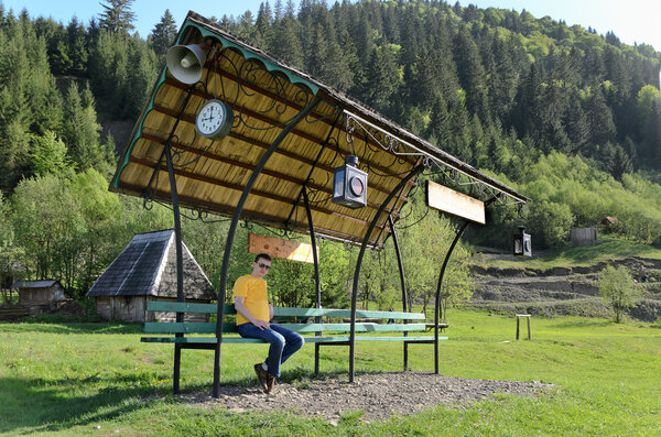 Man sitting on a covered bench in a field