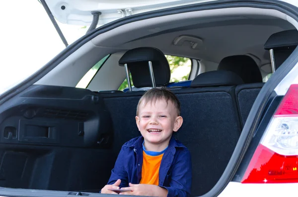 Petit garçon riant assis à l'arrière d'une voiture — Photo