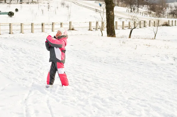 Süße kleine Bruder und Schwester, die sich im Schnee umarmen — Stockfoto