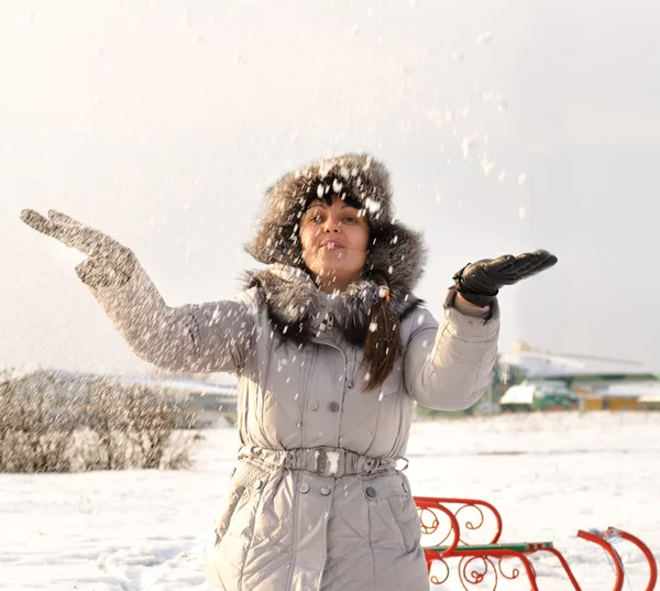 Happy woman throwing snow into the air — Stock Photo, Image