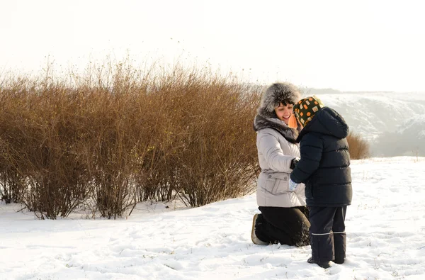 Caring mother checking her sons clothing in winter — Stock Photo, Image