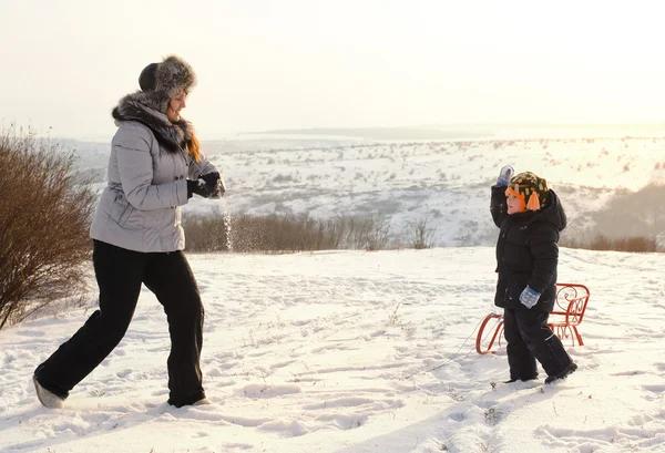 Mutter spielt mit ihrem Sohn im Schnee — Stockfoto