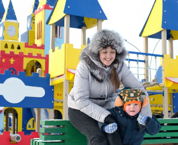 幸せな母と息子は冬の遊び場 — ストック写真