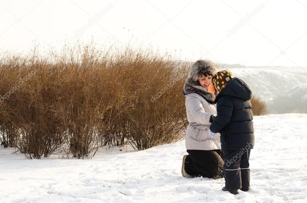 Caring mother checking her sons clothing in winter