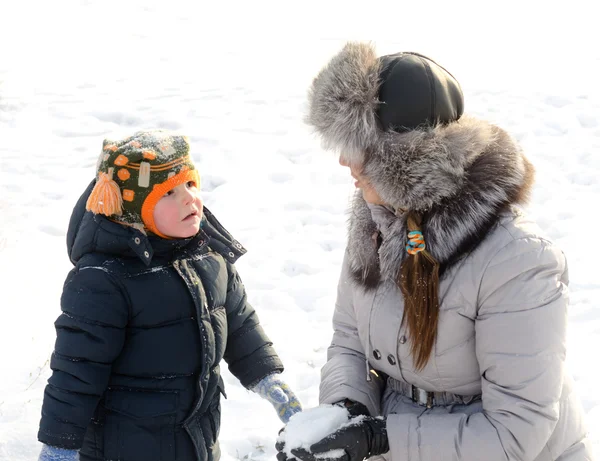 Cute boy playing with his mother in the snow — Stock Photo, Image