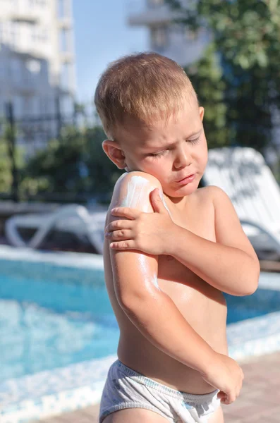 男の子が彼の皮膚に日焼け止めローションを適用します。 — ストック写真