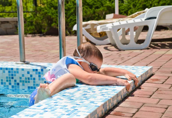 Kleine jongen klauteren uit een zwembad — Stockfoto