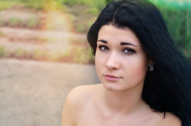 Çıplak omuzlu güzel genç bir kadın.