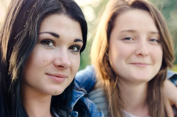 Two beautiful young friends posing arm in arm — Stock Photo, Image