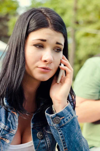 Chica joven escuchando una llamada en su móvil —  Fotos de Stock