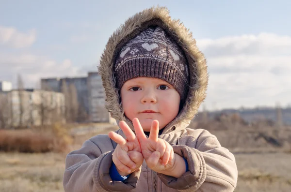 Cute young boy making V-sign gestures — Stock Photo, Image