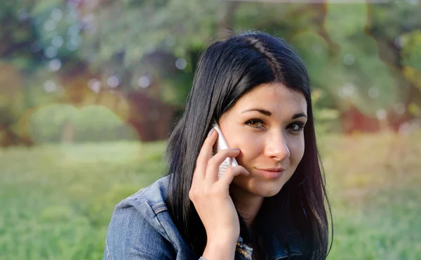 Ung flicka lyssna till ett samtal på sin mobil — Stockfoto