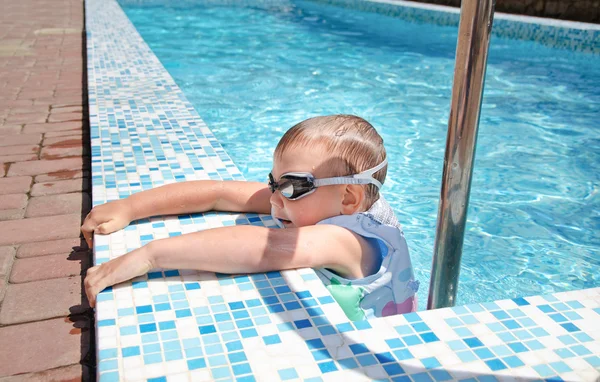 Small boy clambering out swimming pool — Stock Photo, Image