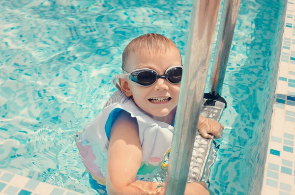 Lachender kleiner Junge klettert aus einem Pool — Stockfoto