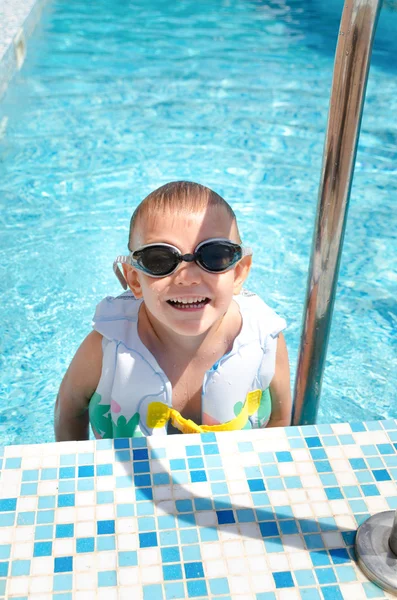 Rapazinho sorridente a sair de uma piscina — Fotografia de Stock