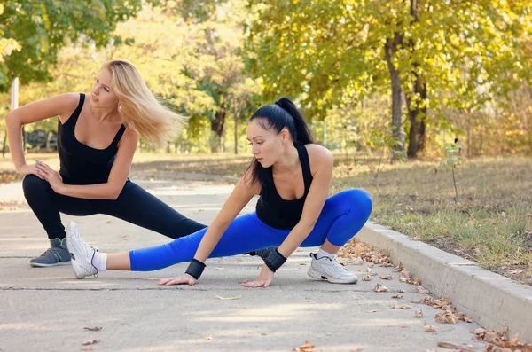 Dos mujeres atléticas en forma haciendo ejercicio en un parque —  Fotos de Stock