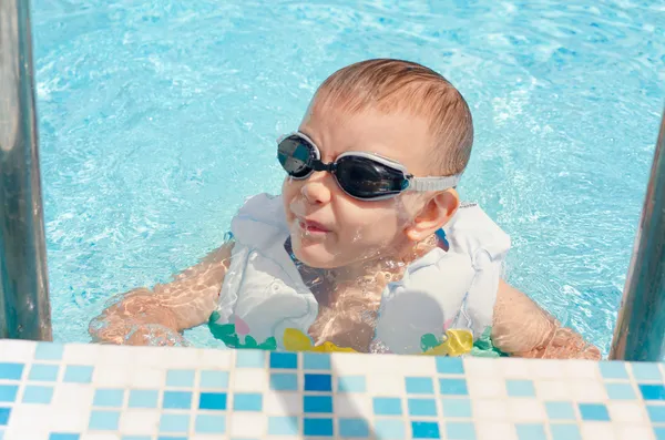 Сміється маленький хлопчик вилазить з басейну — стокове фото