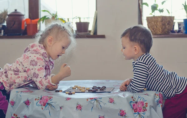 Jovem menino e menina jogando damas — Fotografia de Stock