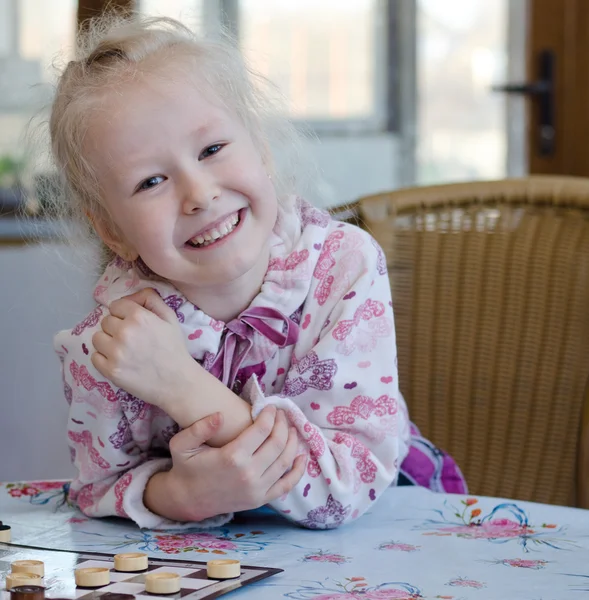 Vacker liten flicka spela en omgång brickor — Stockfoto