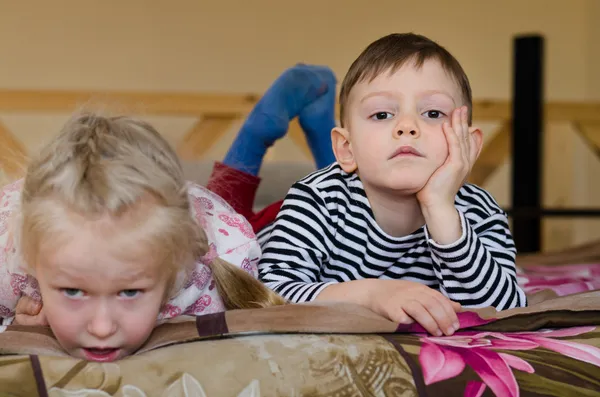 Mladý bratr a sestra, ležící na posteli dohromady — Stock fotografie